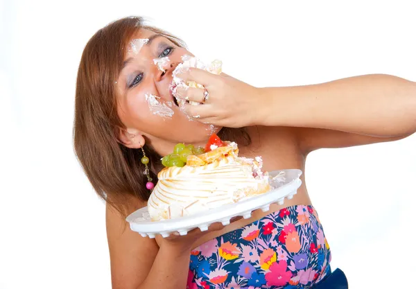 Girl eating cake with hands — Stok fotoğraf