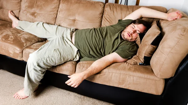 A guy flung all over the couch — Stock Photo, Image