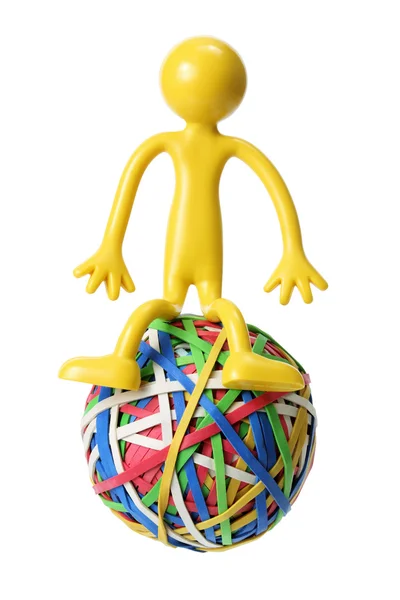 Miniaturní postava sedící na rubberband ball — Stock fotografie