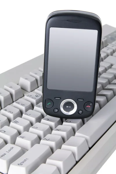 Telefone inteligente no teclado — Fotografia de Stock