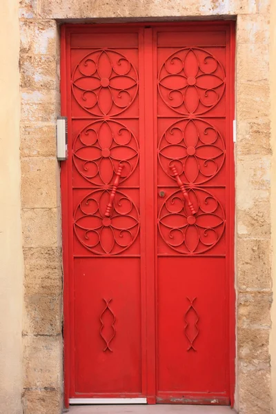 Die dekorative rote Tür auf dem alten Willen des Hauses — Stockfoto