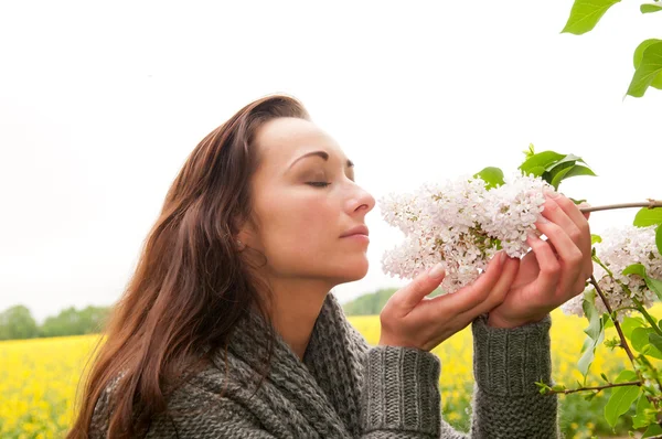 Woman smelling the lilacs — Stock Photo, Image