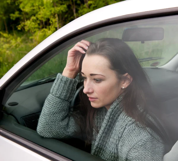 Задумчивая женщина в машине — стоковое фото