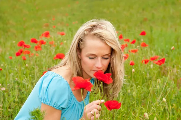 Woman smelling a poppy — Stock Photo, Image