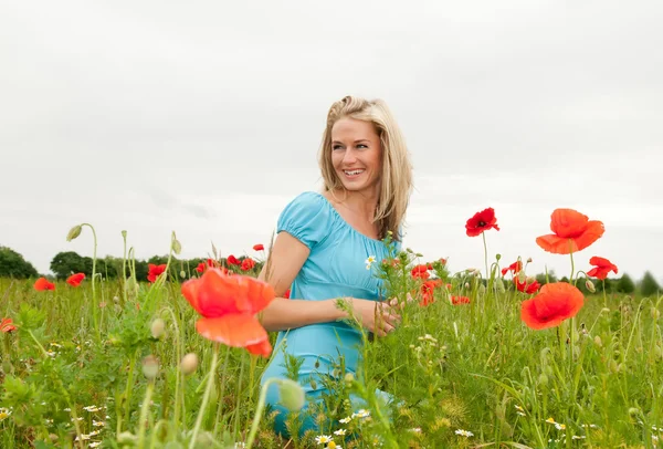 Young woman in poppy field — Stock Photo, Image