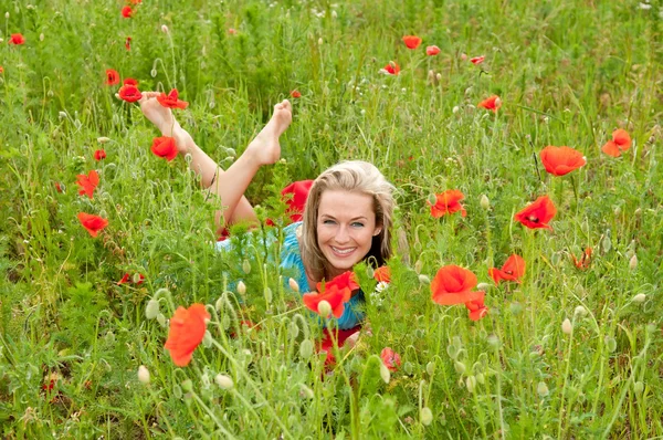 Woman lying in a poppy field — Stock Photo, Image