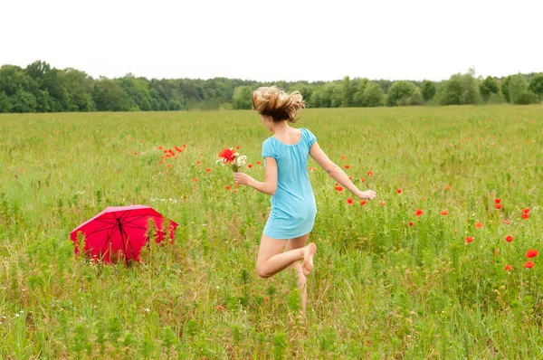 Kobieta idzie przez pole Maków — Zdjęcie stockowe