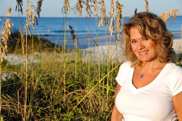 Attraktiv kvinna på stranden vid soluppgång — Stockfoto