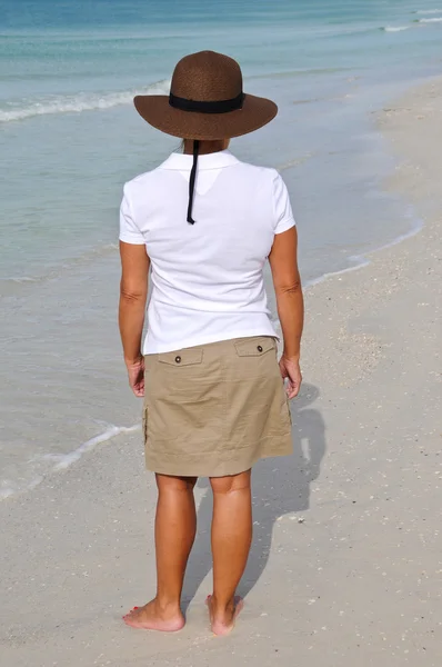 Приваблива жінка стоїть на пляжі — стокове фото