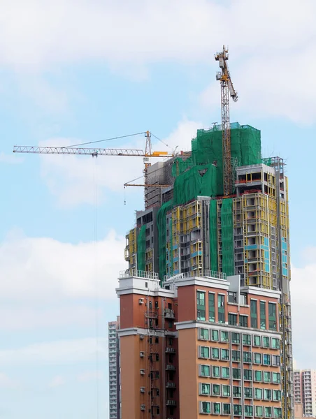 Bouwkraan en gebouw in aanbouw tegen blauwe lucht — Stockfoto