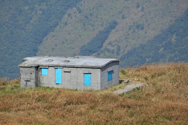 Vieille maison en pierre avec herbe sur la montagne — Photo