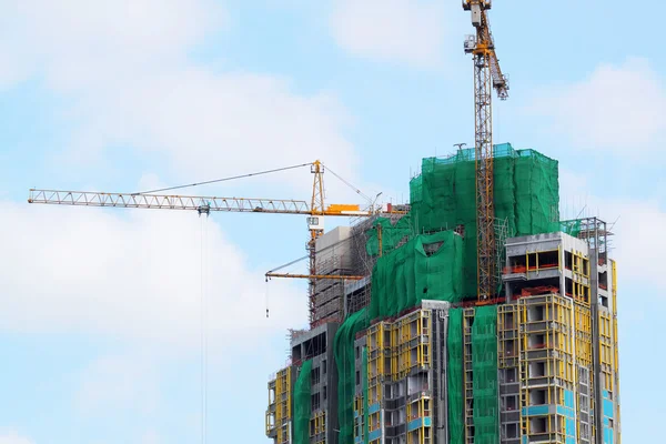 Baukran und Gebäude im Bau vor blauem Himmel — Stockfoto