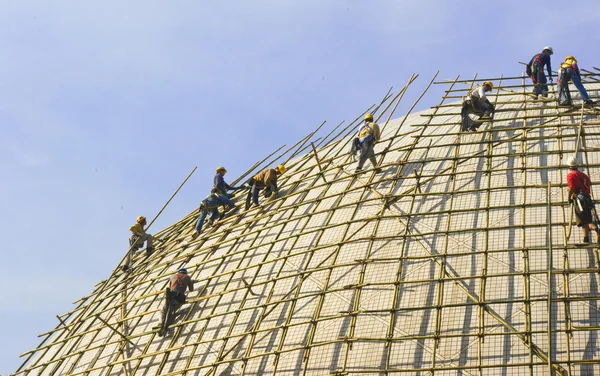Nahaufnahme eines Bauarbeiters, der ein Baugerüst an Gebäuden montiert — Stockfoto