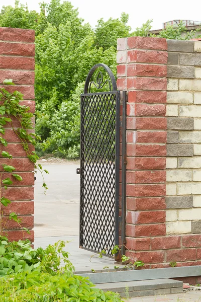 Puerta de metal en la pared de ladrillo — Foto de Stock