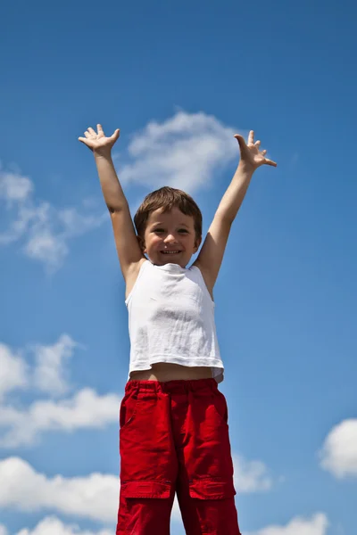 Boy on sky background with raised up hands — Stock Photo, Image