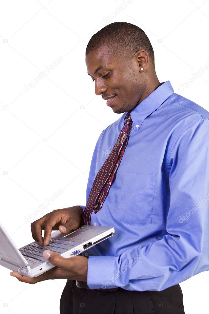 Young black man standing and working on laptop