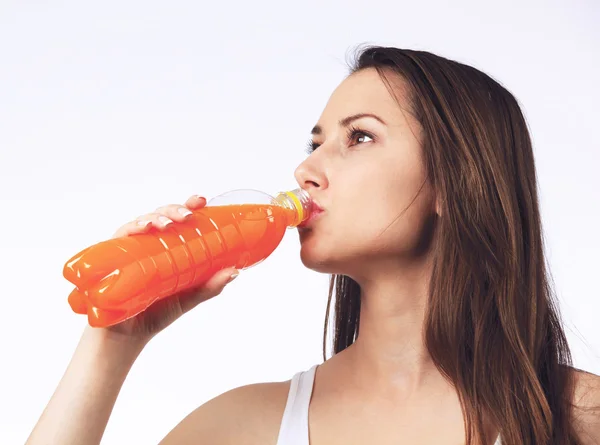 Mladá žena s lahví pomerančové šťávy — Stock fotografie