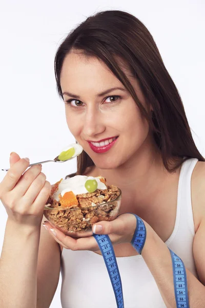Ung kvinna med en skål med frukostflingor — Stockfoto