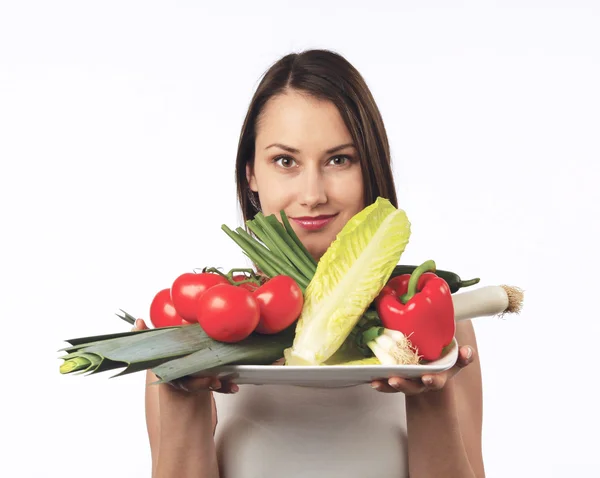 Νέα γυναίκα που κρατά ένα πιάτο με φρέσκα λαχανικά — Φωτογραφία Αρχείου