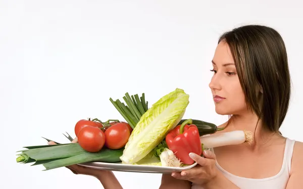 Young woman holding a plate with fresh vegetables Royalty Free Stock Images