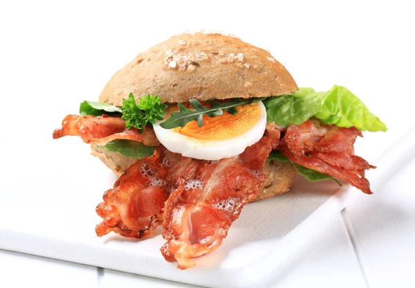 Bread bun with crispy bacon — Stock Photo, Image
