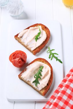 Crispy bread with spread and salami clipart