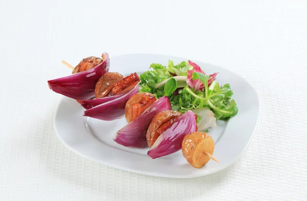 Bacon and potato skewer with salad greens — Stock Photo, Image