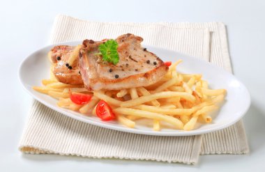 Pan fried pork chops with fries clipart