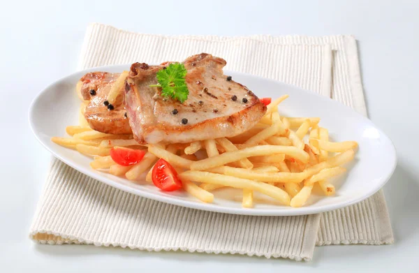 Pan fried pork chops with fries — Stock Photo, Image
