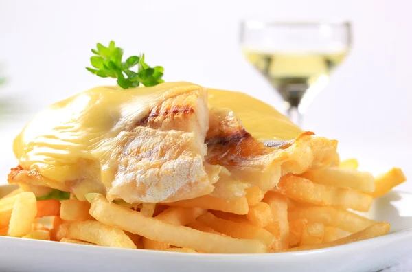 Cheese topped fish fillets with French fries — Stock Photo, Image