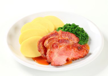 Smoked pork neck with potato dumplings and spinach clipart