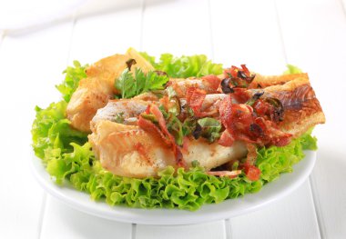 Pan fried fish fillets with bacon bits clipart