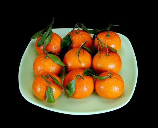Mandarinas en un plato sobre un fondo negro —  Fotos de Stock