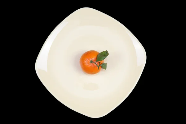 Mandarino su un piatto su fondo nero — Foto Stock