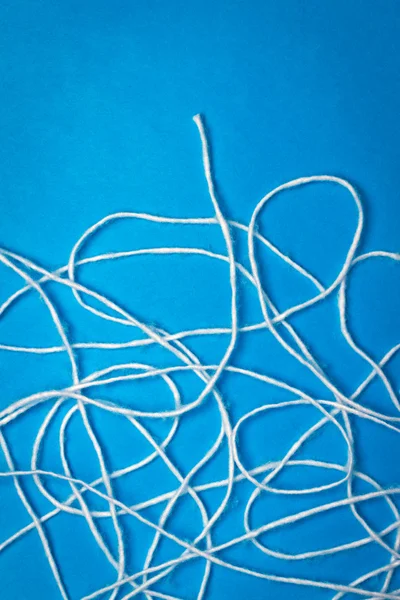 Abstract white wool strings on blue background with copy space — Stock Photo, Image
