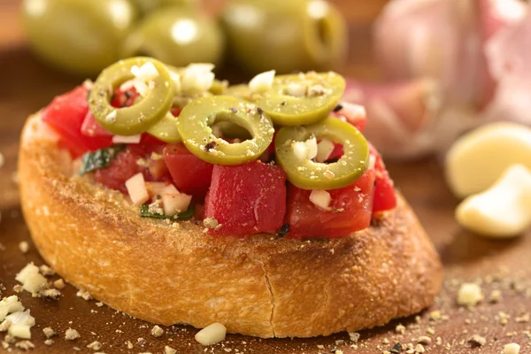 Bruschetta con tomate, aceitunas verdes, ajo y albahaca —  Fotos de Stock