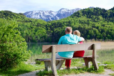 Elderly couple rests on bench clipart