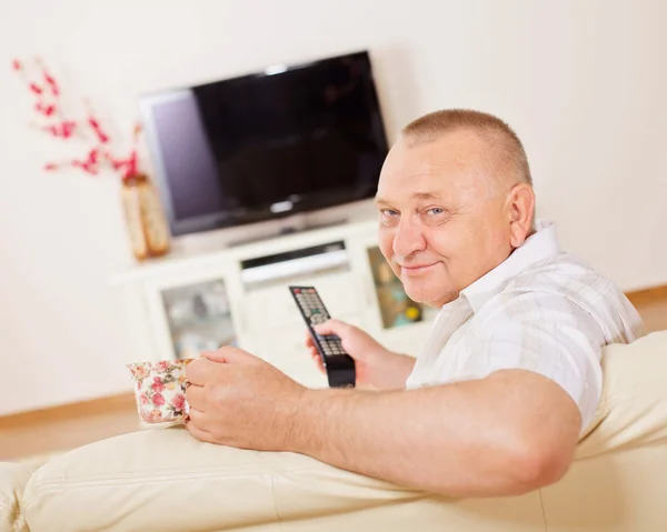 Улыбающийся мужчина смотрит телевизор — стоковое фото