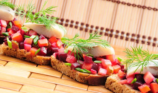 Sandwiches with rye bread, herring and vegetables — Stock Photo, Image