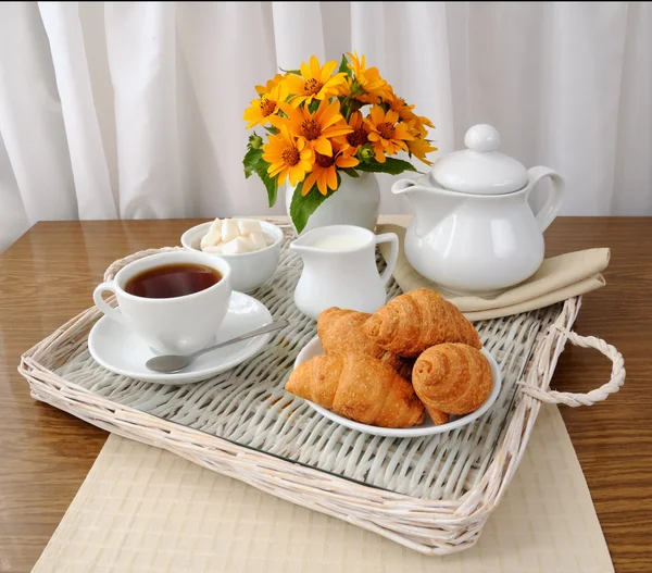 Croissants with tea and milk on a tray — Stock Photo, Image