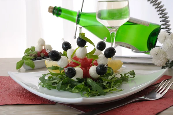 Appetizer of mozzarella, cherry tomatoes and olives with Arugula — Stock Photo, Image