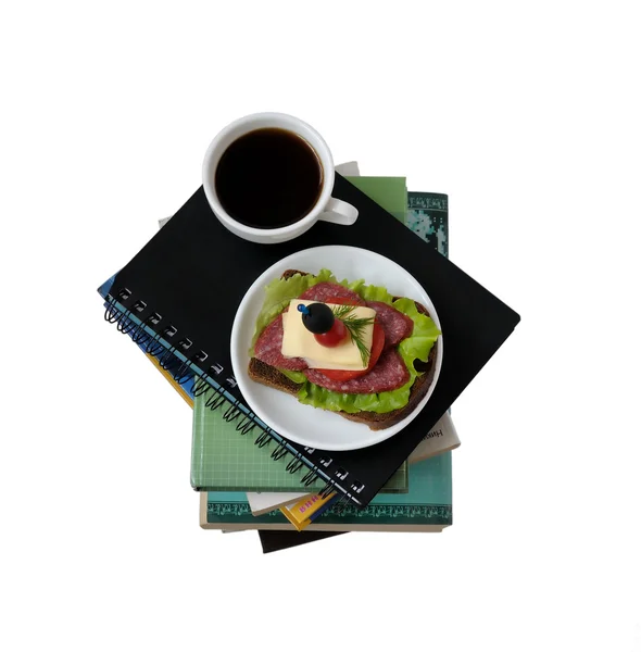 En trave böcker och anteckningsböcker med en kopp kaffe och en sandwi — Stockfoto