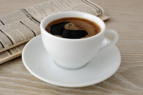 Una taza de café y un periódico — Foto de Stock