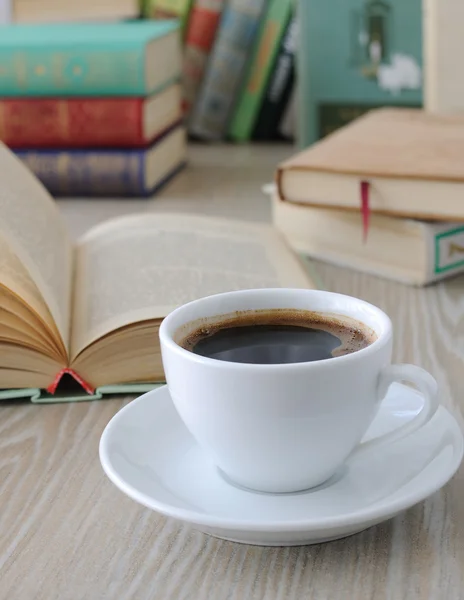 Tasse Kaffee auf einem Tisch mit Büchern Stockbild