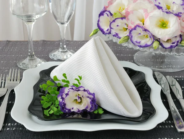 Pratos pretos e brancos servidos com um guardanapo com flores — Fotografia de Stock
