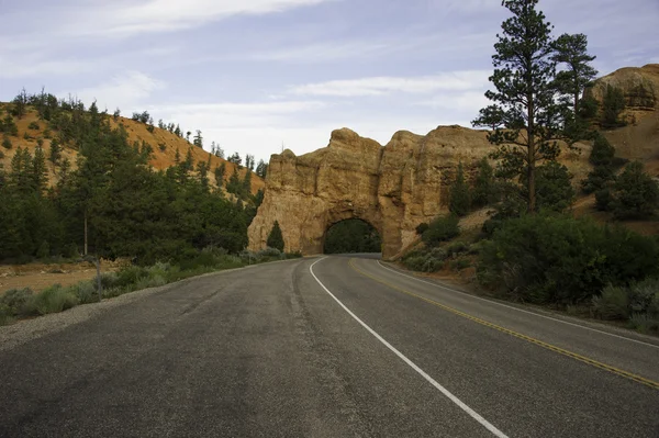 Roadway going through rock arch — Stock Photo, Image