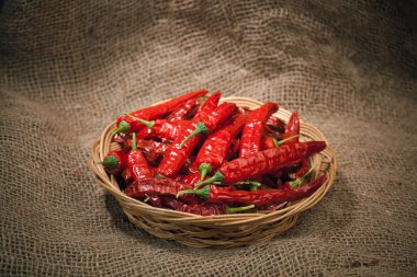 Red chili peppers on the wicker dish clipart