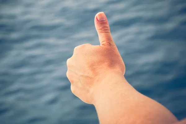 Thumbs up na pozadí moře — Stock fotografie