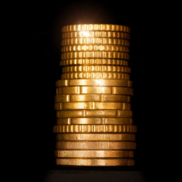 Column of golden money isolated on black — Stock Photo, Image