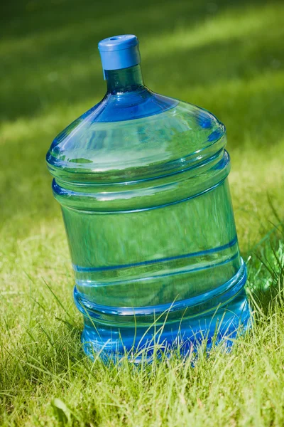 Água grande garrafa no fundo grama verde — Fotografia de Stock